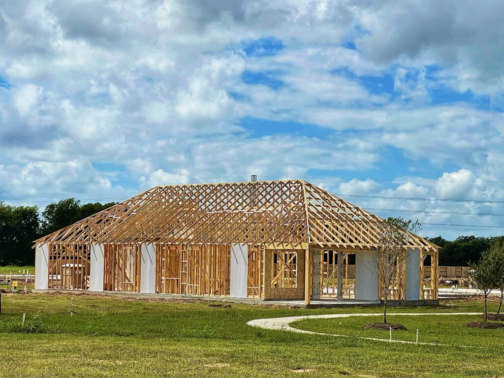 New home framing underway on a grassy lot in Ozark, Missouri.